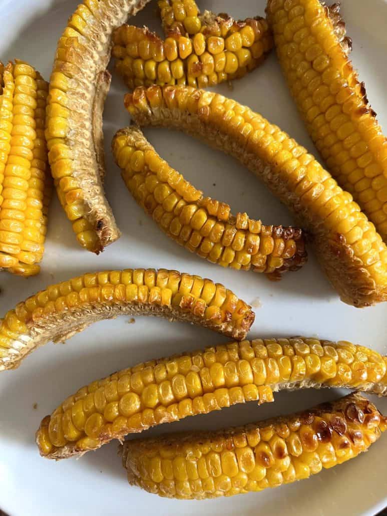 Plate of golden, air-fried corn ribs with a perfectly crispy exterior, ready to serve as a tasty side or snack.