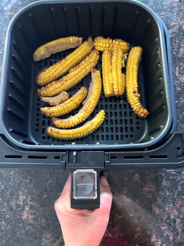 Trader Joe's seasoned corn ribs arranged in a single layer in the air fryer basket,