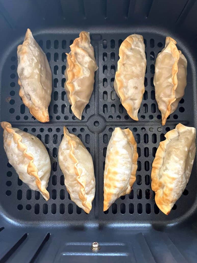 Top view of crispy and mouth watering, eight perfectly air-fried Mandu dumplings in a basket.