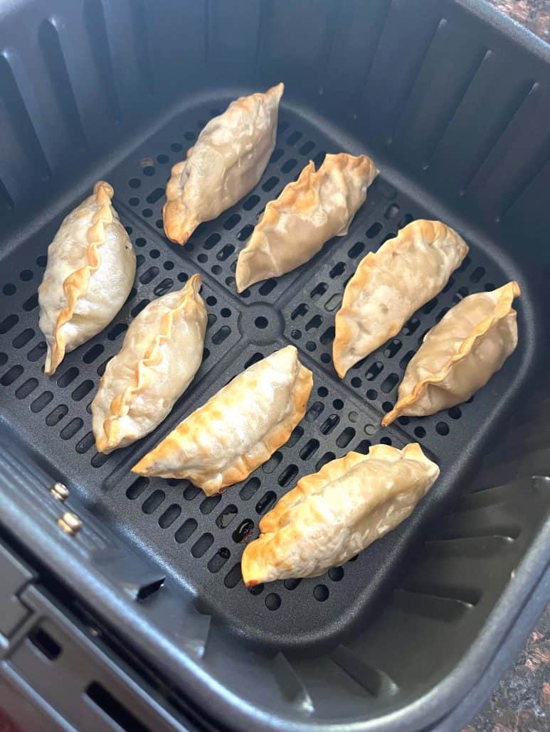 Perfectly crispy finish, Mandu dumplings in an air fryer basket.