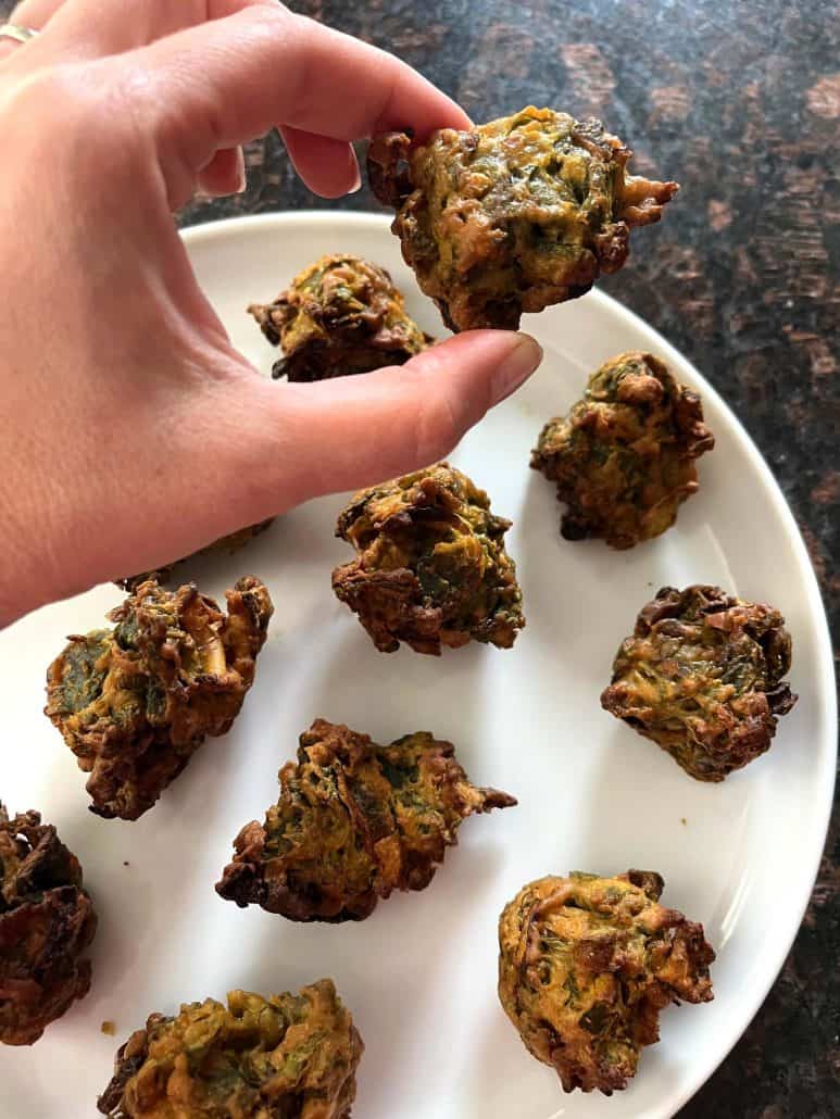 Hand holding the crispy, delicious pakora snack.