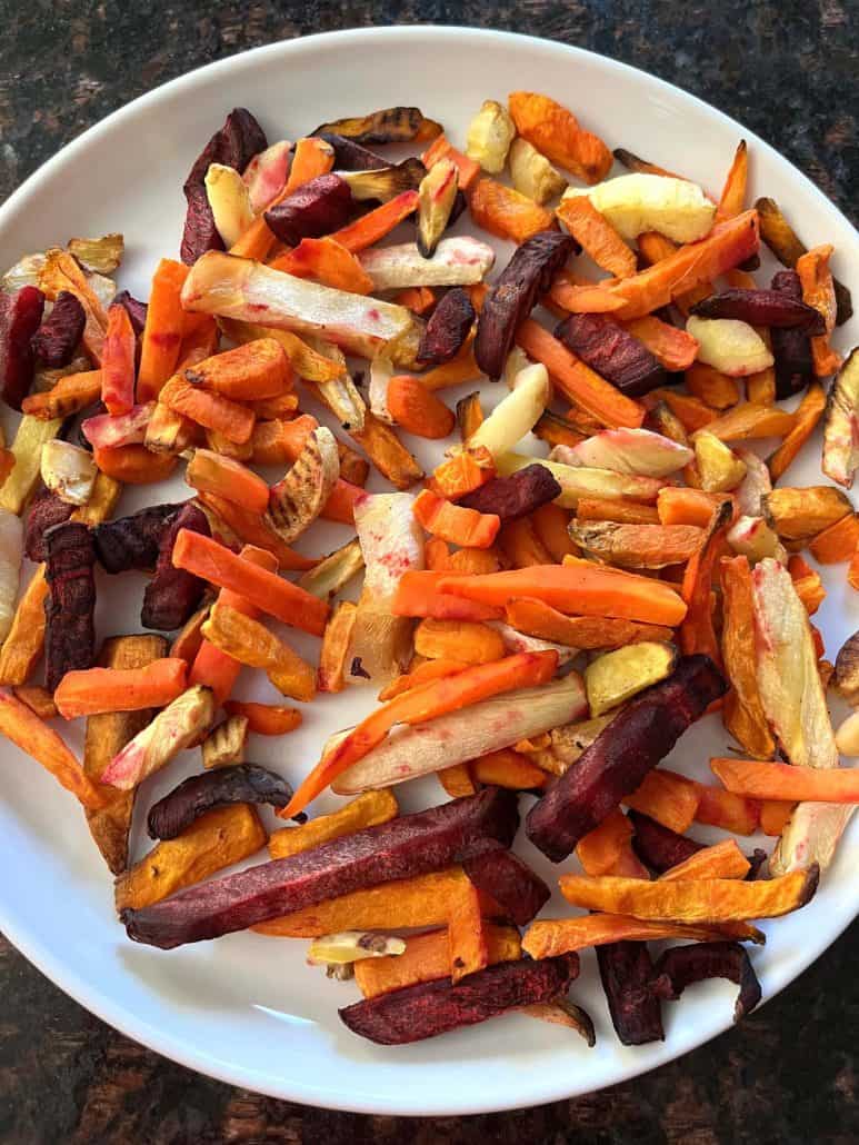 Plate of freshly cooked root vegetable fries, featuring a colorful mix of sweet potatoes, carrots, beets, and parsnips.