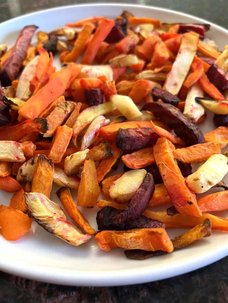 Plate of cooked root vegetable fries, including sweet potatoes, carrots, beets, and parsnips, air-fried to a crispy, golden finish.