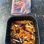 Frozen Trader Joe's Root Vegetable Fries placed in an air fryer basket, ready to be cooked as a nutritious and colorful side dish.