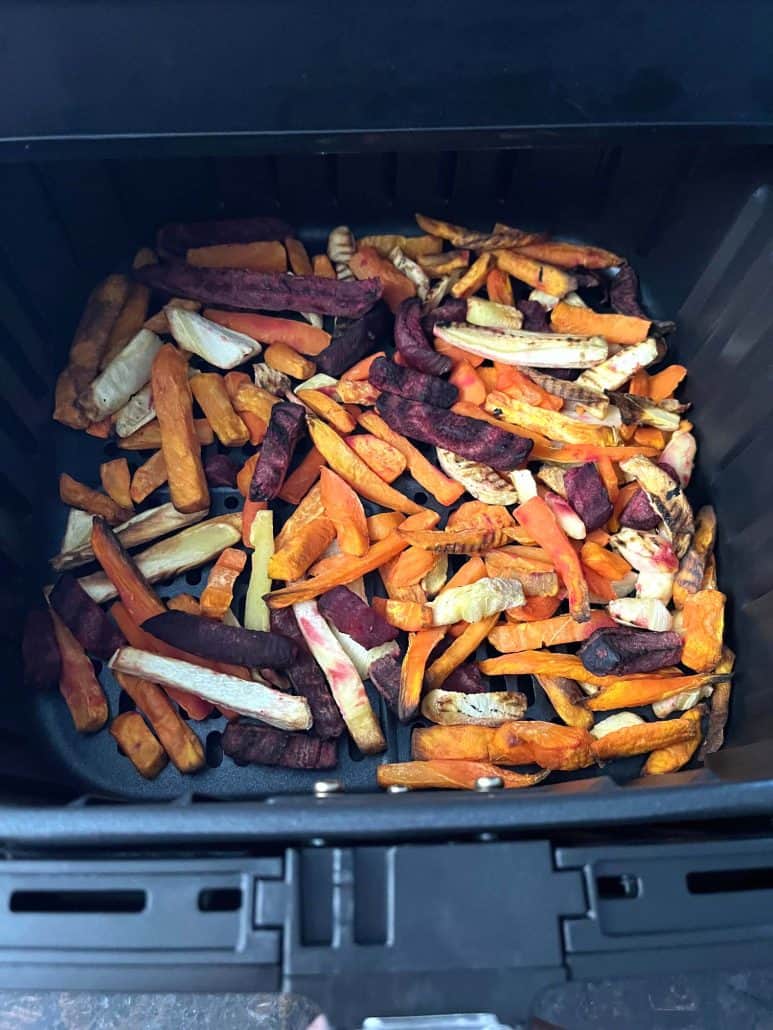 Air fryer basket filled with frozen root vegetable fries, ready to be cooked into a crispy and healthy snack.