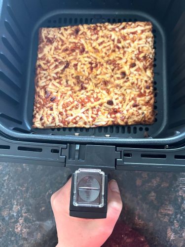 Crispy Totino’s Party Pizza freshly cooked in an air fryer basket.