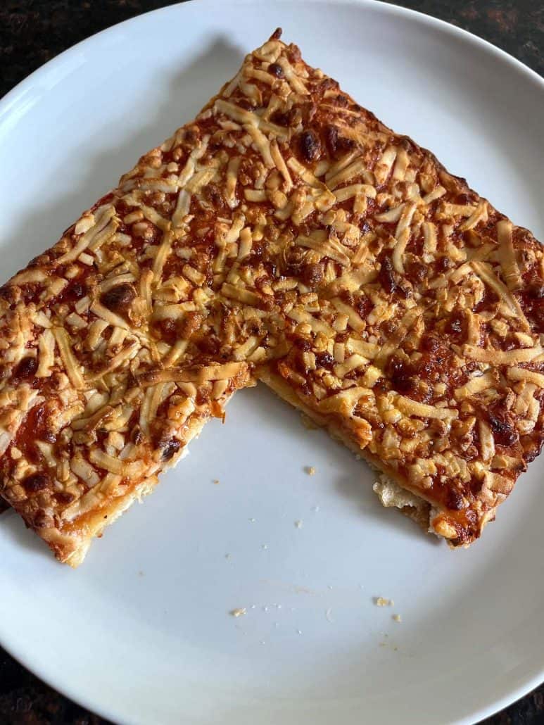 Air-fried Totino's Party Pizza on a white plate, showing the browned crust and melted cheese.