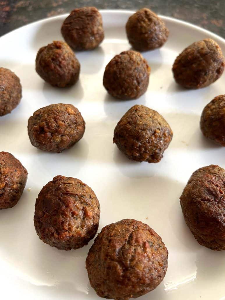 Another angle of perfectly crispy Meatballs on a white plate,