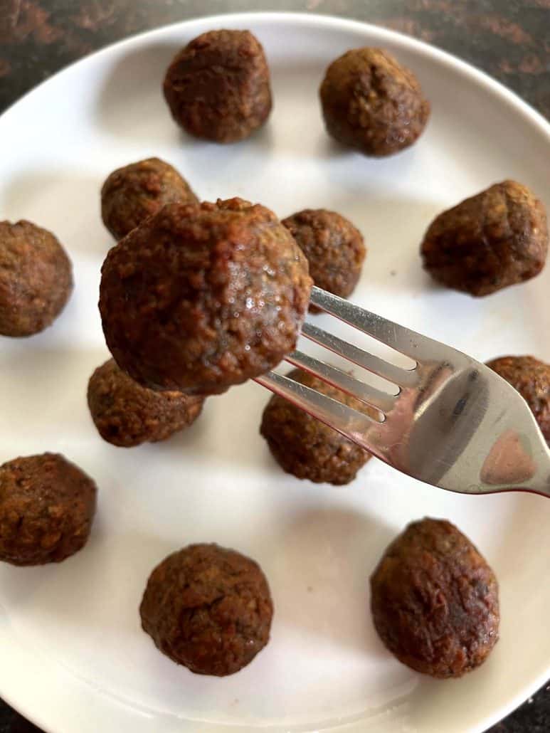 Top view of a fork piercing an air-fried Impossible Meatball.