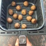 Air fryer basket filled with cooked Impossible Vegan Meatballs, golden and crispy, ready to serve as a quick and tasty plant-based meal.