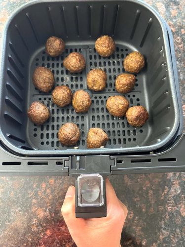 Air fryer basket filled with cooked Impossible Vegan Meatballs, golden and crispy, ready to serve as a quick and tasty plant-based meal.