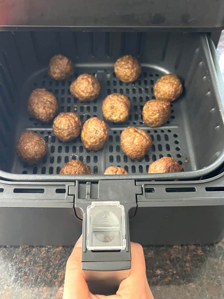 Freshly cooked Impossible Meatballs in an air fryer basket.