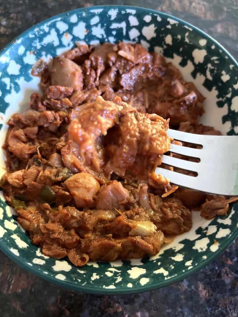 Close-up of cooked Tex-Mex jackfruit in a bowl with a fork.