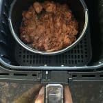 Cooked pre-seasoned jackfruit in a pan inside an air fryer basket, showing the easy preparation process for the Air Fryer Jackfruit recipe.