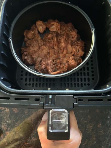 Cooked pre-seasoned jackfruit in a pan inside an air fryer basket, showing the easy preparation process for the Air Fryer Jackfruit recipe.