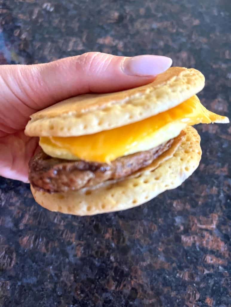 Fully assembled Jimmy Dean Maple Griddle Cake sandwich with sausage, egg, and melted cheese, freshly made in the air fryer.