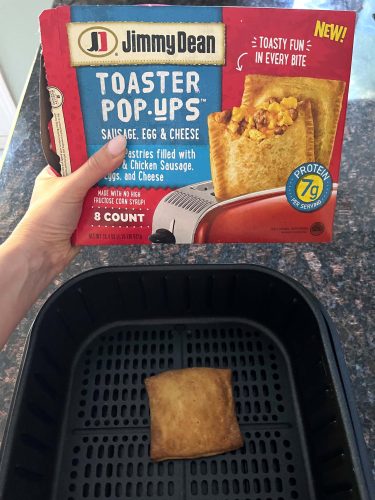 A hand holding a package of Jimmy Dean Toaster Pop Ups alongside perfectly cooked, crispy toaster pop ups fresh from the air fryer, ready to enjoy.