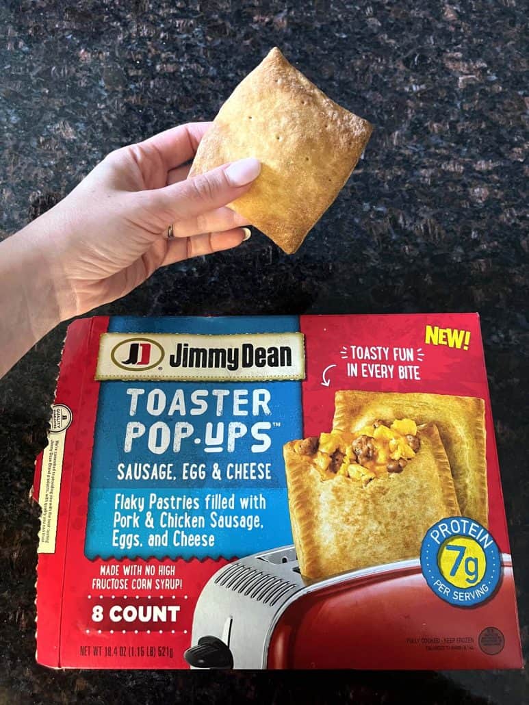 Hand holding the ready to eat toaster pop-ups, alongside with its Jimmy Dean Package.