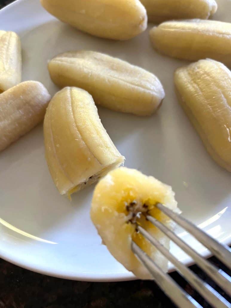 Fork holding a bite of boiled Saba banana.