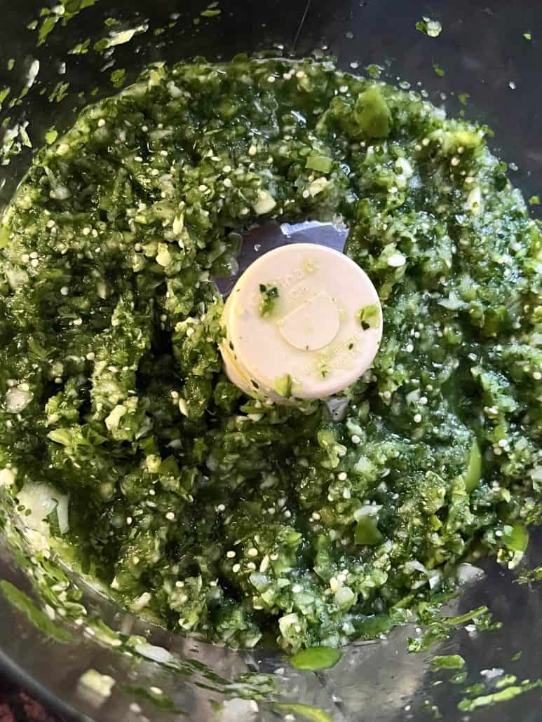 Close-up of bright green, slightly chunky texture of tomatillo salsa verde.