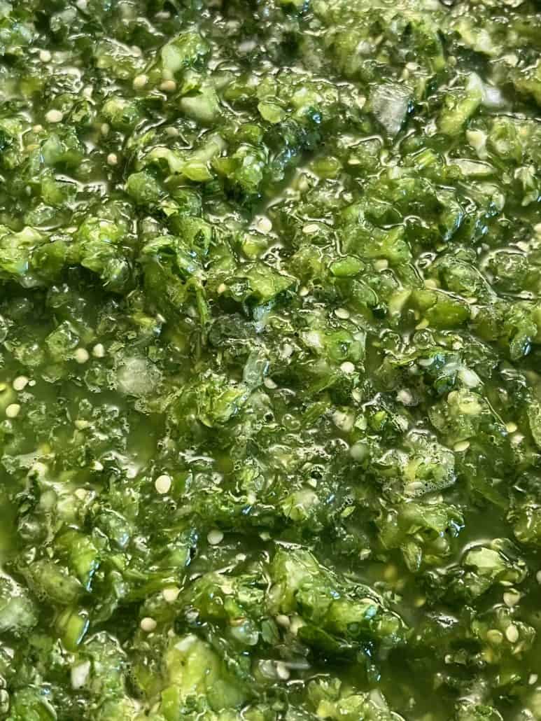 Close-up of chunky, vibrant green tomatillo salsa verde, showcasing the fresh texture and ingredients.