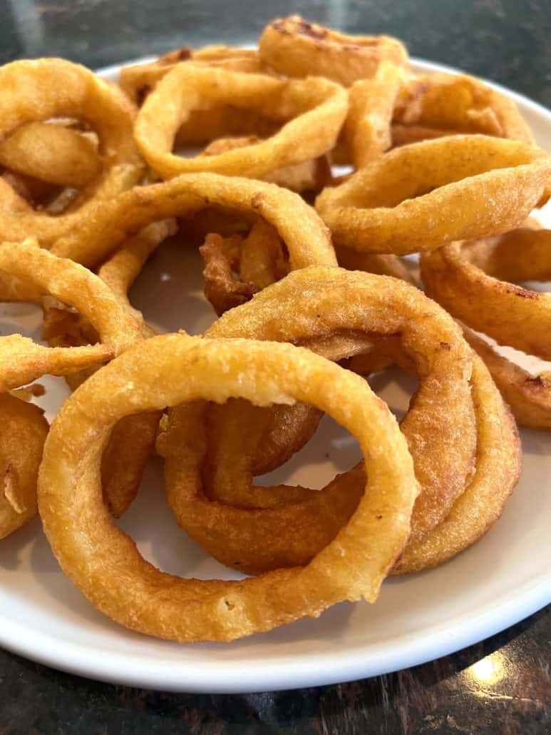 A plate filled with crispy, golden onion rings, highlighting their perfect texture and crunch.