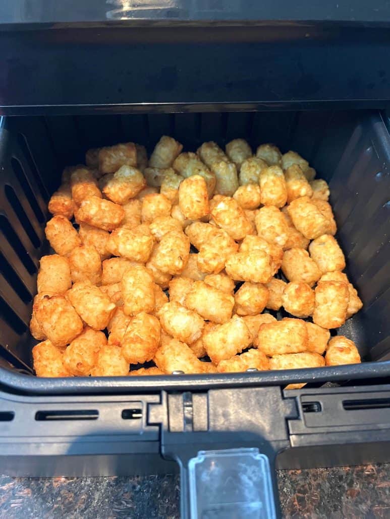 Sonic tater tots perfectly cooked in the air fryer basket.