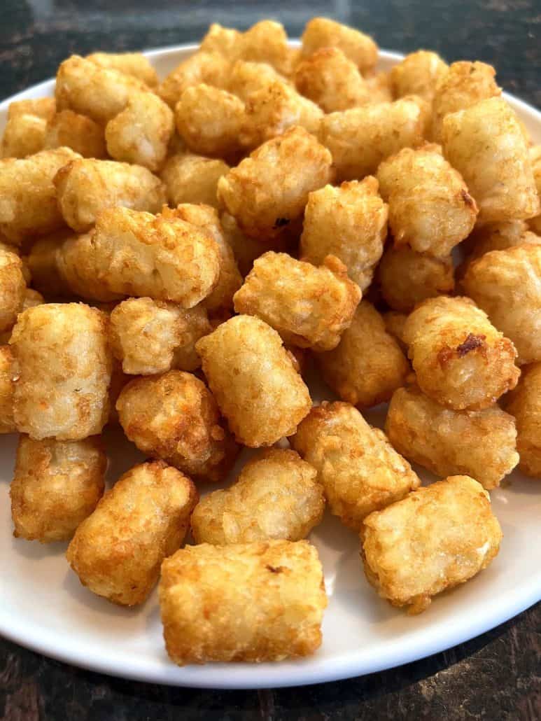 Plate of perfectly golden and crispy Sonic tater tots, ready to enjoy.