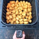 Freshly air-fried Sonic tater tots in the basket, golden and crispy.