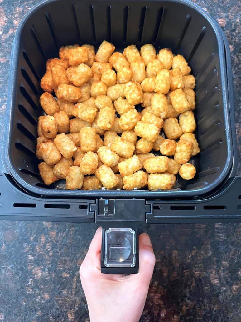 Freshly air-fried Sonic tater tots in the basket, golden and crispy.