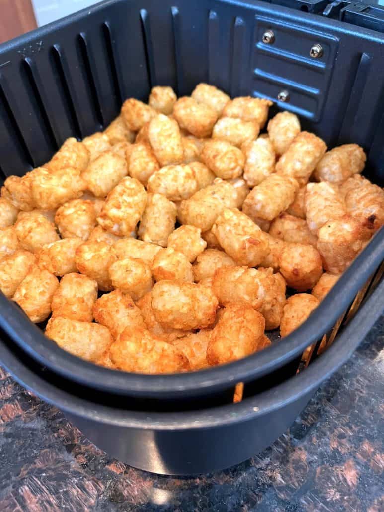 Perfectly golden texture of crispy Sonic tater tots in the air fryer basket.