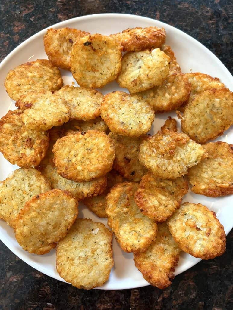 Plate of golden and crispy McCain Baby Cakes Hashbrowns, freshly cooked and ready to serve as a delicious snack or side dish.