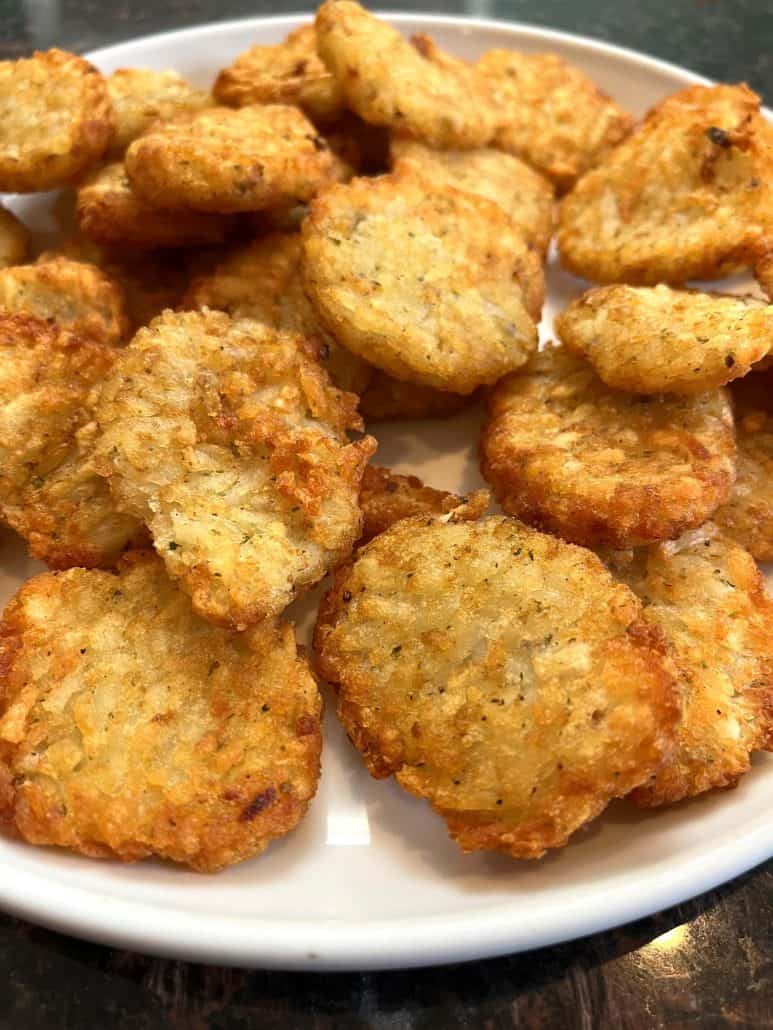 Side view of a plate filled with golden and crispy McCain Baby Cakes Hashbrowns, ready to be served as a tasty side or snack.