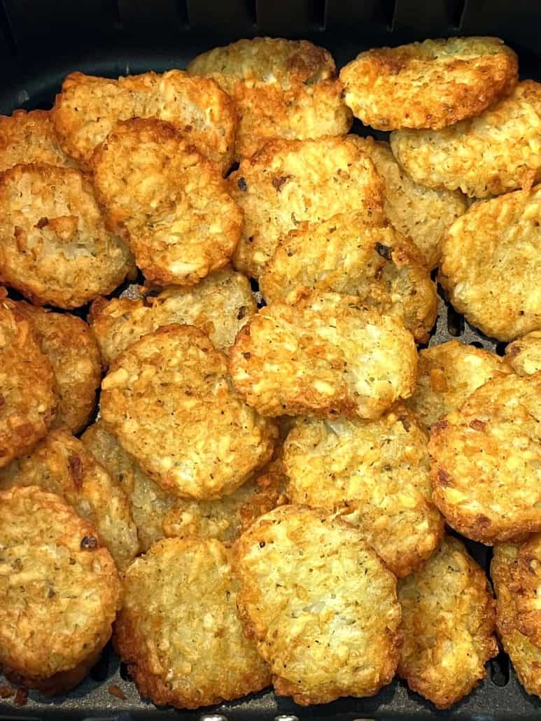 Detailed view of golden-brown McCain Baby Cakes Hashbrowns freshly cooked in an air fryer.