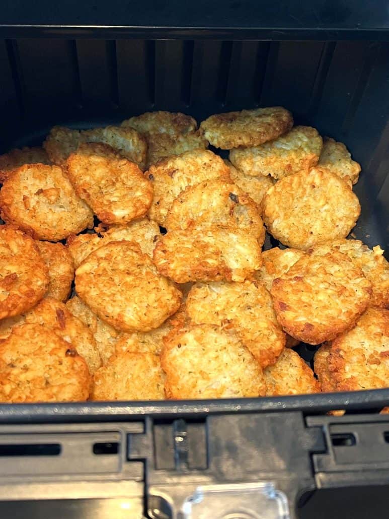 Close-up of crispy, golden McCain Baby Cakes Hashbrowns perfectly cooked in an air fryer basket.