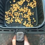 Freshly roasted pumpkin seeds in an air fryer basket, golden and crispy, ready to enjoy as a healthy snack.