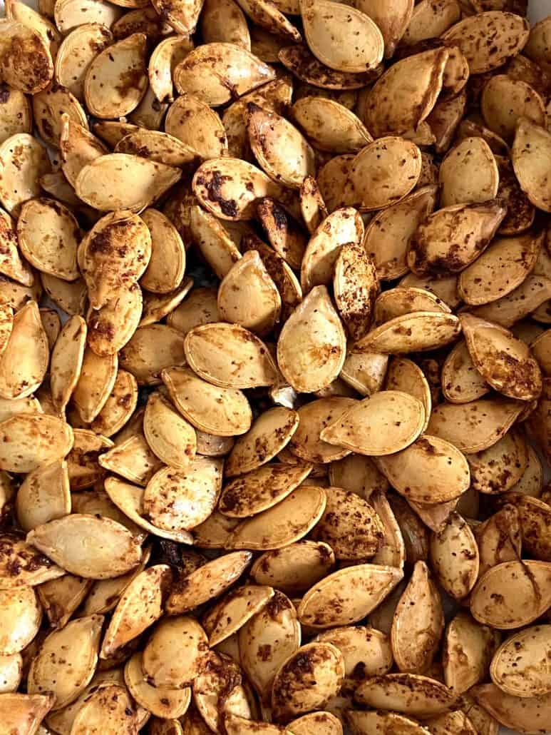 Close-up view of perfectly roasted pumpkin seeds, showcasing their golden brown color and crunchy texture.