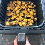 Golden, roasted pumpkin cubes in an air fryer basket, showcasing the easy and delicious result of the Air Fryer Pumpkin recipe.