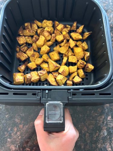 Golden, roasted pumpkin cubes in an air fryer basket, showcasing the easy and delicious result of the Air Fryer Pumpkin recipe.