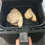 Two seasoned swordfish fillets cooking in an air fryer basket, demonstrating the simplicity of cooking frozen fish in an air fryer for a quick, healthy meal.