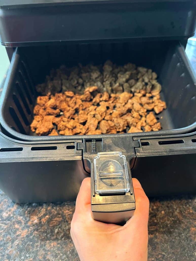 Frozen Beyond Steak Tips placed in an air fryer basket, ready to be cooked to perfection for a quick and easy vegan meal.