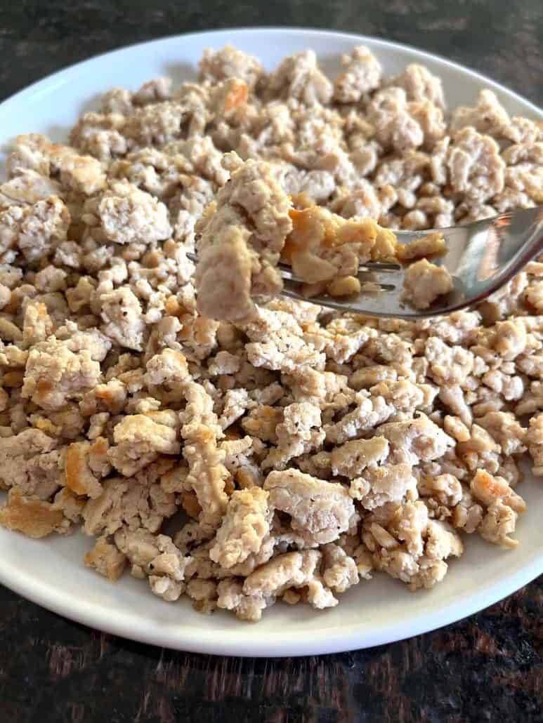 Cooked ground chicken served on a plate with a fork, ready to be enjoyed or added to your favorite recipe.