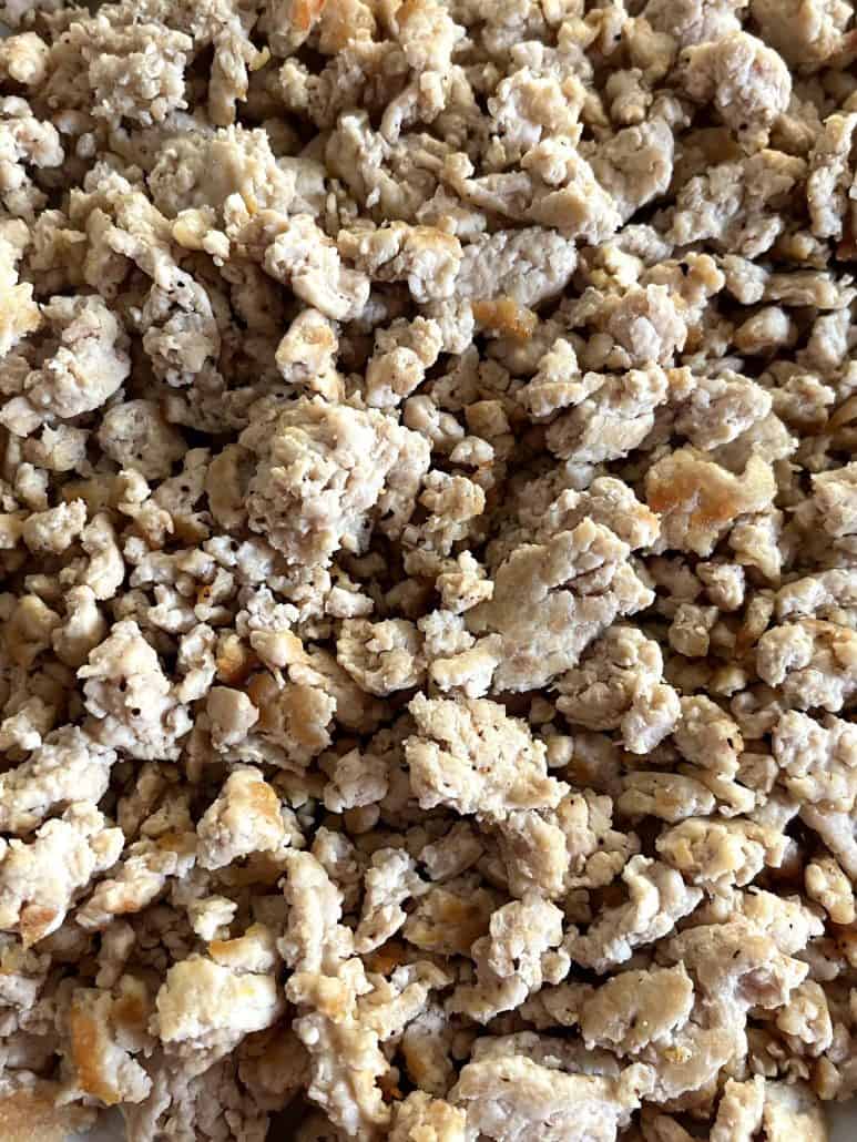 Close-up texture of cooked ground chicken, showing its tender and crumbly consistency,