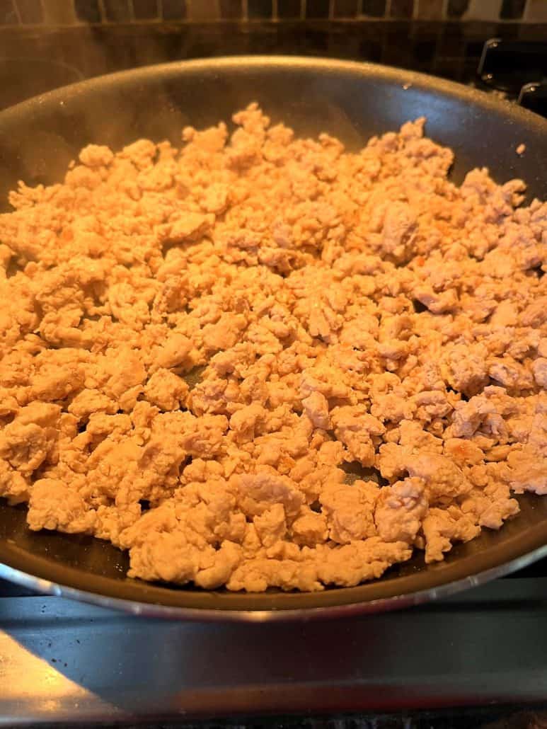 Perfectly cooked ground chicken, lightly browned in a frying pan.