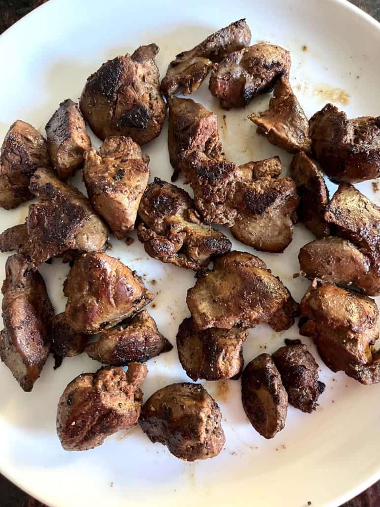 Plate of freshly cooked, golden-brown chicken livers, showcasing their crispy exterior and tender texture.