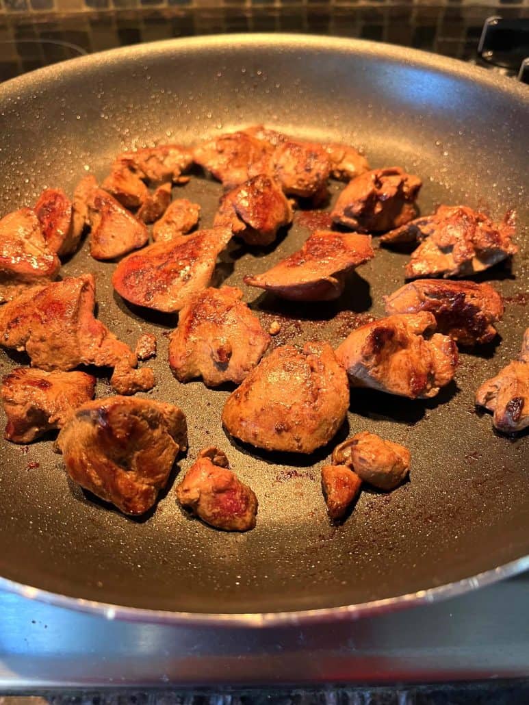 Golden-brown chicken livers cooking evenly in a non-stick frying pan, ready to serve.