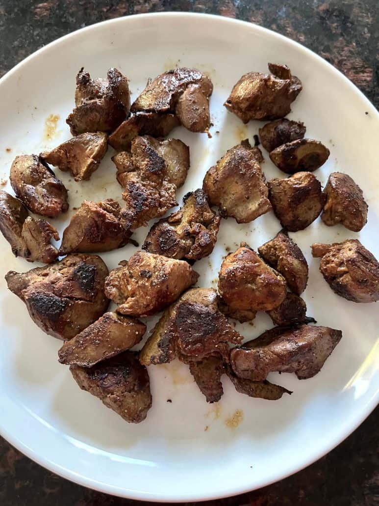 Plate of crispy, golden-brown sauteed chicken livers, freshly cooked and ready to serve as a nutrient-rich, flavorful meal.