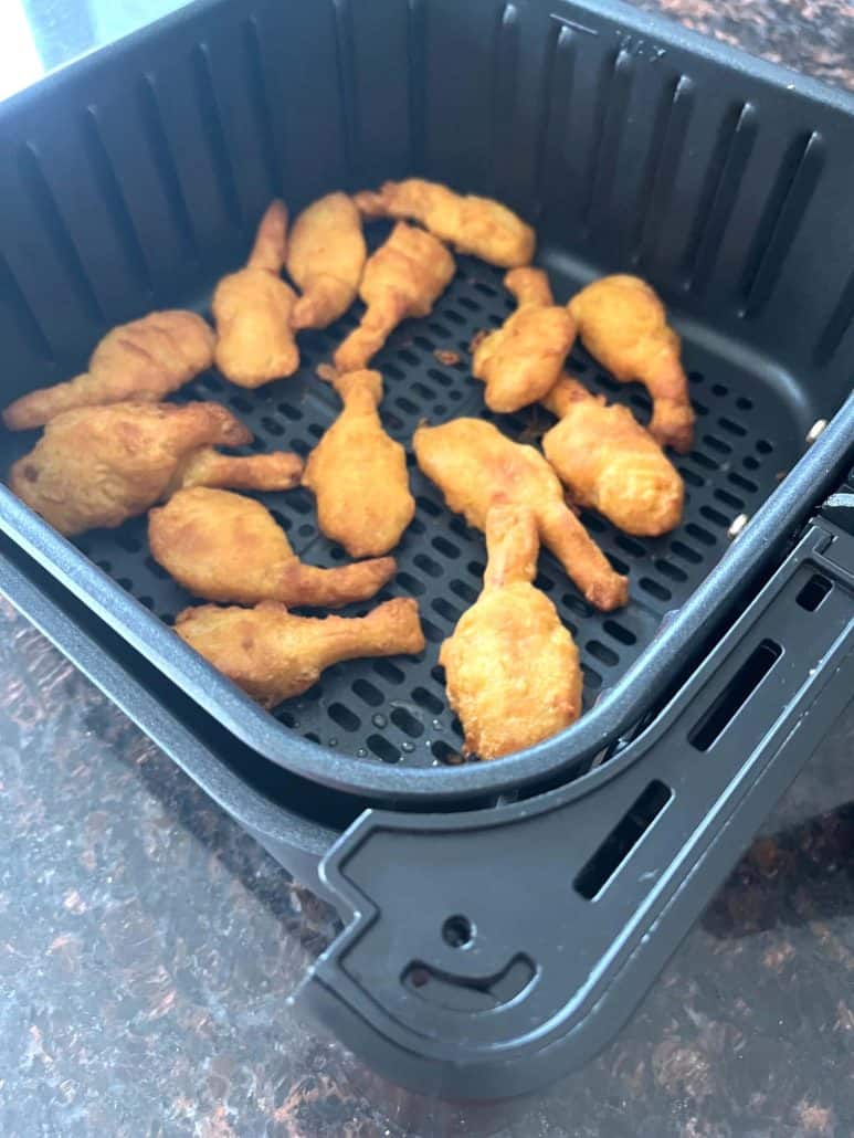 Golden, crispy beer-battered shrimp arranged in an air fryer basket, showcasing their crunchy texture and even cooking, perfect for a quick and tasty snack or meal.