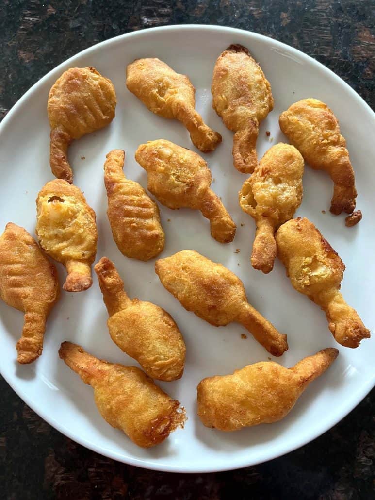 Golden, crispy beer-battered shrimp arranged on a white plate, highlighting their crunchy texture and ready-to-serve appearance, perfect for appetizers or snacks.