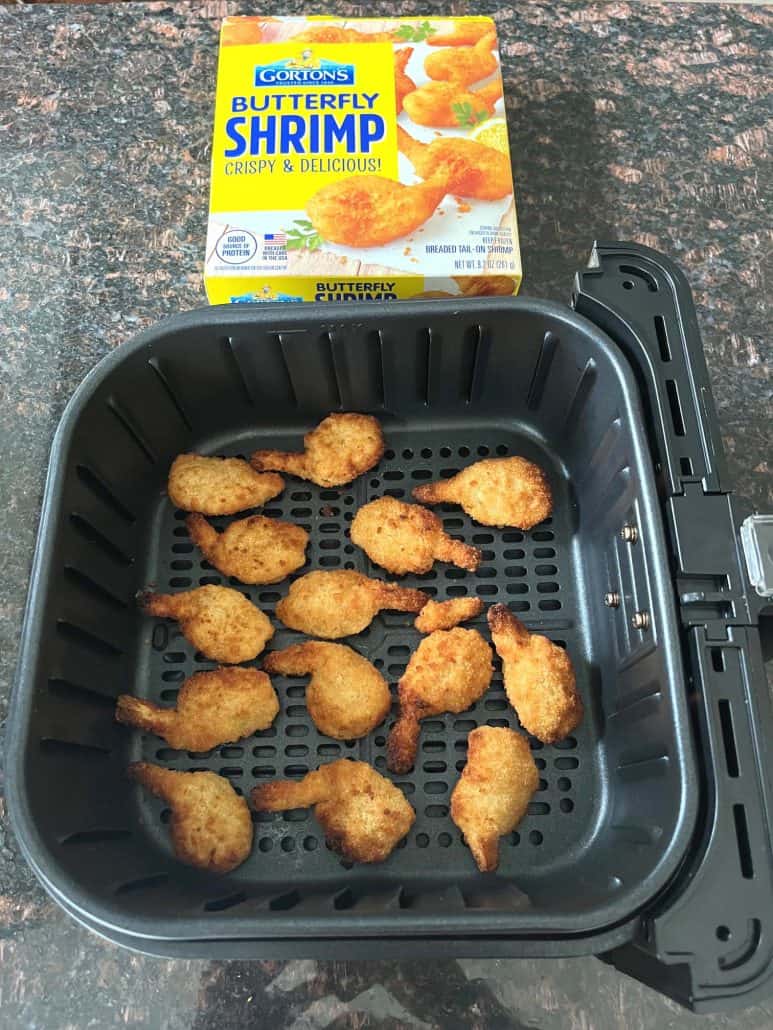 Golden brown butterfly shrimp cooked in the air fryer basket, displayed with a box of Gorton's Butterfly Shrimp in the background.